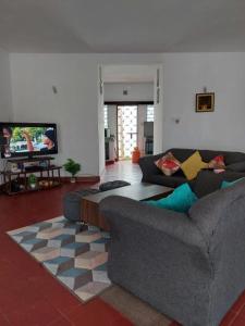 uma sala de estar com dois sofás e uma televisão em Sea whispers em Mombaça
