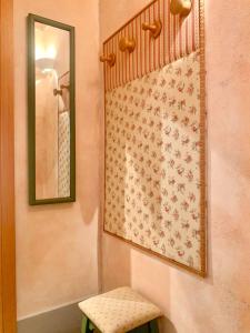 a bathroom with a mirror and a stool next to a wall at Casa il Cassero in Castiglion Fiorentino
