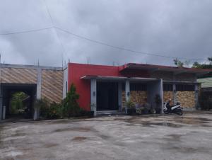 een gebouw met een motor geparkeerd op een parkeerplaats bij OYO 93152 Azwa Gh Katingan 