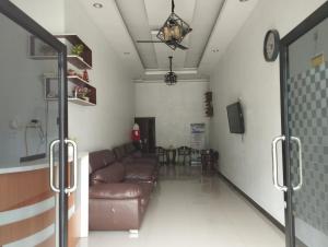 een woonkamer met een bank en een tafel bij OYO 93152 Azwa Gh Katingan 