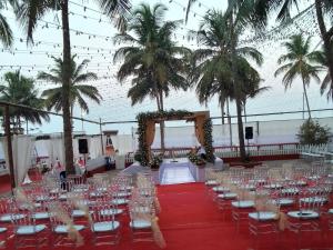 - une salle de banquet avec des tables, des chaises et des palmiers dans l'établissement Liberty House - SeaView, à Kozhikode
