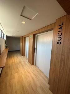 an office hallway with wooden floors and a door at Way Bossa Praia do Bessa in João Pessoa
