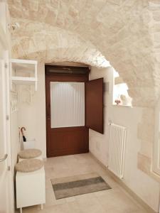 un pasillo con una puerta en una pared de piedra en L'Artefice, en Locorotondo