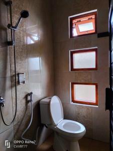 La salle de bains est pourvue de toilettes, d'une douche et d'une fenêtre. dans l'établissement SA VILLA, à Batu