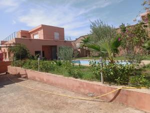 ein Haus mit einem gelben Schlauch vor einem Hof in der Unterkunft BUILD KECH Agafay Marrakech in Marrakesch