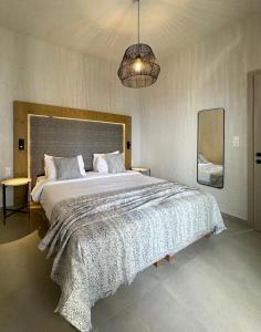a bedroom with a large bed and a pendant light at Okeanis Mystique South in Ierapetra