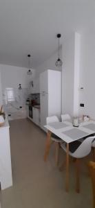 a white room with a table and a kitchen at L’angolo d’aMare in Lerici