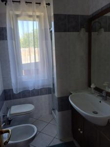 ein Bad mit einem Waschbecken, einem WC und einem Fenster in der Unterkunft Campo del Gatto in Viterbo