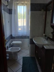 a bathroom with a sink and a toilet and a window at Campo del Gatto in Viterbo