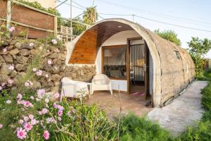 uma casa com uma parede de pedra e duas cadeiras e flores em Espacio Antares em Icod de los Vinos