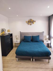 1 dormitorio con 1 cama con edredón azul en Lumineux Charming Appartement - Cozy Flat, en Le Chesnay