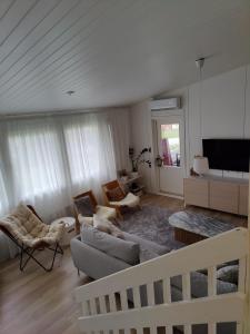 a living room with a couch and chairs and a tv at Sunstar Villa in Rovaniemi