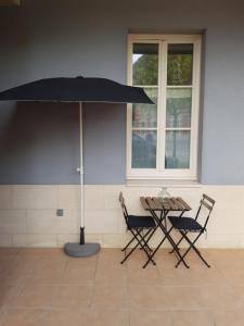 スラック・シュル・メールにあるAppt plein coeur de Soulac sur Merのテーブルと椅子、パラソル付