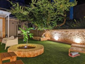 a garden with a tree in the middle of a yard at Little gem by the sea in Chania