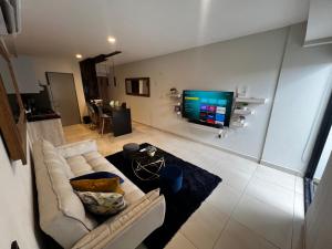 a living room with a couch and a flat screen tv at Departamento Inteligente con Jacuzzi Privado en Zapopan in Guadalajara