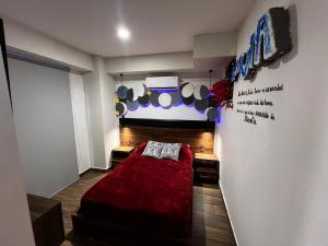 a bedroom with a red bed and a wall at Departamento Inteligente con Jacuzzi Privado en Zapopan in Guadalajara
