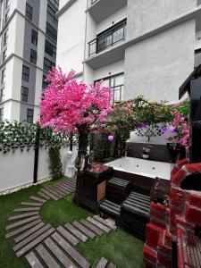 a garden with pink flowering trees and a bath tub at Departamento Inteligente con Jacuzzi Privado en Zapopan in Guadalajara