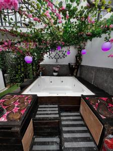Departamento Inteligente con Jacuzzi Privado en Zapopan في غواذالاخارا: حوض الاستحمام مع الزهور المعلقة من السقف