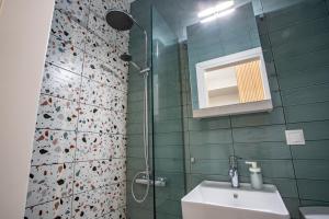 a bathroom with a sink and a shower with a mirror at Little gem by the sea in Chania