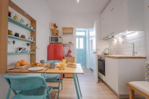 a kitchen with a wooden table and blue chairs at Little gem by the sea in Chania