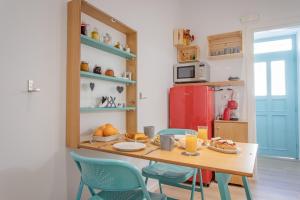 a kitchen with a table and chairs with food on it at Little gem by the sea in Chania +13 photos