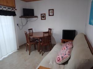 sala de estar con mesa, sillas y sofá en El Reposo de Eladia 1 en Quequén