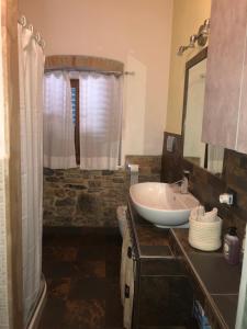 a bathroom with a sink and a toilet and a mirror at Vacanza in Chianti in Badia A Passignano