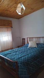 1 dormitorio con cama azul y almohada en El Reposo de Eladia 1 en Quequén