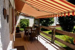 een patio met een tafel en een houten pergola bij Ferienhaus Gabriela Allgäu in Immenstadt im Allgäu