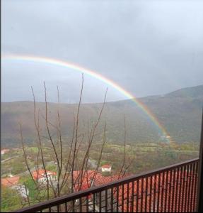 un arco iris en el cielo con balcón en Άγρια Λούλουδα Κατοικία Ευτυχία, en Timfristós