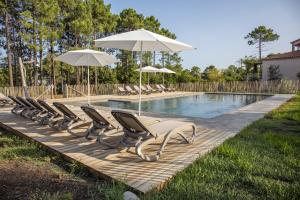 una fila de sillas y sombrillas junto a una piscina en Domaine de Pianiccia, en Favone