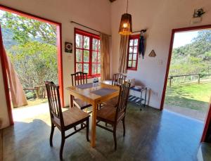 a dining room with a wooden table and chairs at Pousada Vale das Araucárias in Santo Antônio do Pinhal