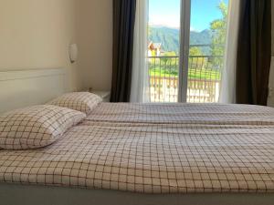 Bett mit zwei Kissen vor dem Fenster in der Unterkunft Fliess Apartment in Fliess