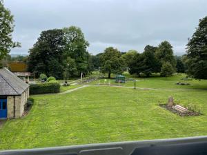 a park with a playground with a slide at The Queens Head, Parkside Apartment 1 in Burley in Wharfedale