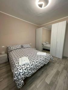 ein Schlafzimmer mit einem großen Bett mit einer schwarzen und weißen Decke in der Unterkunft Da Francesco in Pisa