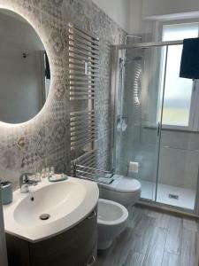 un bagno con lavandino, WC e specchio di Da Francesco a Pisa