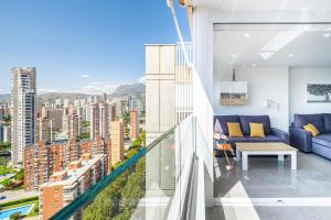 d'un balcon avec un canapé bleu et une table. dans l'établissement Gemelos 22-3-21D Apartment Deluxe Levante Beach, à Benidorm