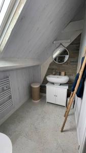 a small bathroom with a sink and a mirror at Maison vue mer Omaha Beach in Vierville-sur-Mer