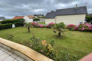 a yard with flowering plants and a house at Maison vue mer Omaha Beach in Vierville-sur-Mer