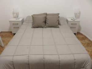 a bed in a room with two night stands at Oasis Palermo Soho in Buenos Aires