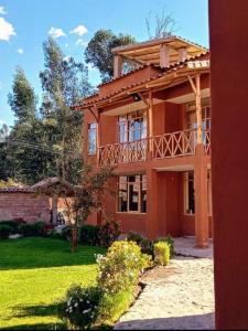 a large house with a balcony on top of it at Allin Illary Eco Hospedaje in Urubamba