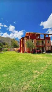 a house with a green lawn in front of it at Allin Illary Eco Hospedaje in Urubamba
