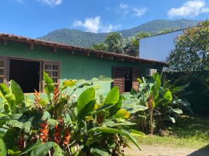Recanto dos Katzen في ماريسياز: منزل أخضر مع جبال في الخلفية