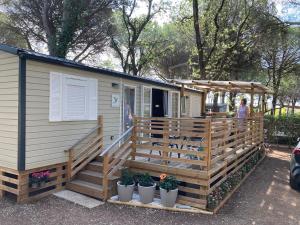 uma pequena casa com um alpendre e um deque em La Baume 515 em Fréjus