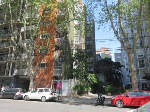 a building with cars parked in front of it at Oasis Palermo Soho in Buenos Aires
