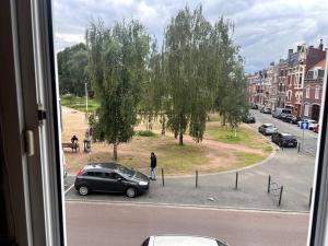 een uitzicht vanuit een raam van een straat met een auto bij Studios tres chaleureux in Roubaix