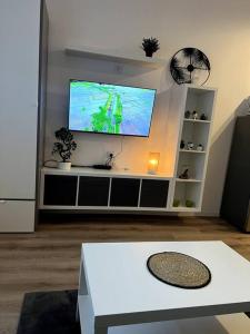 een woonkamer met een flatscreen-tv aan de muur bij Studios tres chaleureux in Roubaix