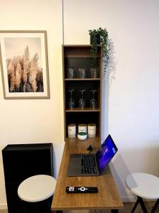 een laptop op een houten tafel met twee krukken bij Studios tres chaleureux in Roubaix