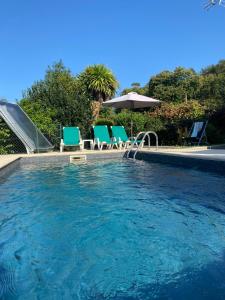 a swimming pool with chairs and a slide at Casa da Lage - Gerês in Geres