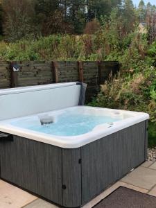 a jacuzzi tub sitting on a patio at Red Squirrel Pod with Hot Tub in Oban